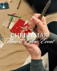 Hände bemalen eine Kugel mit dem Titel Christmas Flow & Glow Event